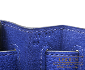 London, UK. 30th Nov, 2021. A bleu electrique Clémence leather retourné  Kelly 32, Hermès, 2014, est £7,000-9,000 with a rouge vif ostrich leather  birkin 30, Hermès, 2015, est £10,000-15,000 and a jaune
